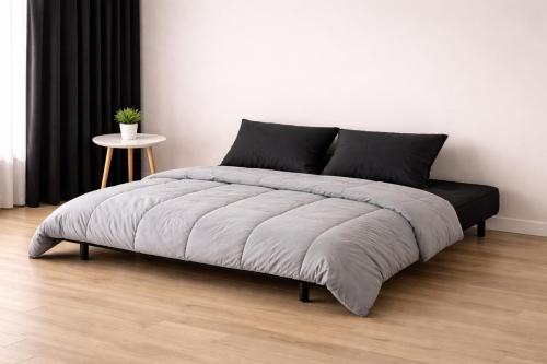 a bed in a white room with a white wall at Résidence Le poisson d'or in Perros-Guirec