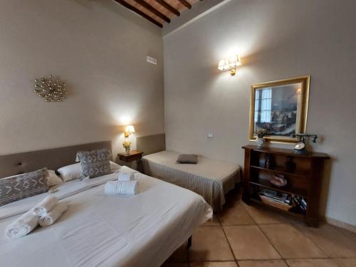 a hotel room with two beds and a mirror at Affittacamere Caliani in Buonconvento