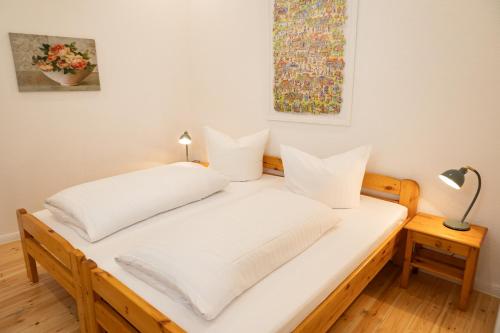 a white bed with two pillows on top of it at Ferienwohnung am Kirchplatz in der Altstadt in Rinteln