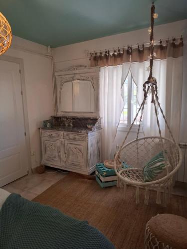a room with a chair and a mirror and a dresser at Au Jardin d'Armand in Sant Pere de Ribes