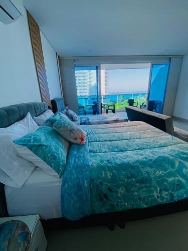 a bedroom with a large bed and a large window at Reserva del Mar 539 in Santa Marta