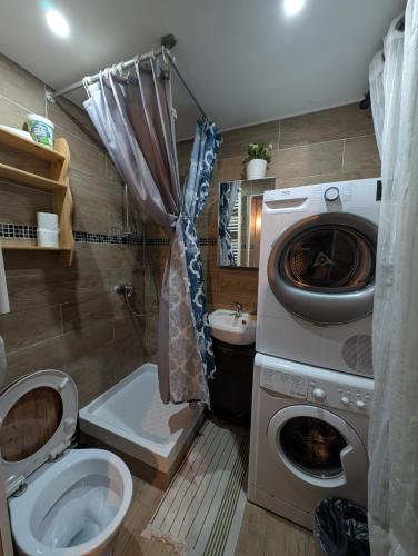 a bathroom with a washing machine and a toilet at Saint Georges - ParisSmile in Villeneuve-Saint-Georges