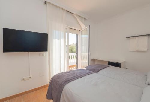 a white bedroom with a bed and a large window at Coliving Torremolinos Casa privada in Torremolinos