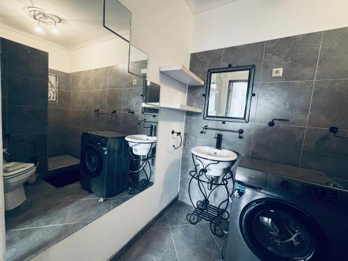 a bathroom with a sink and a washing machine at Austra Deluxé Villa in Windhoek