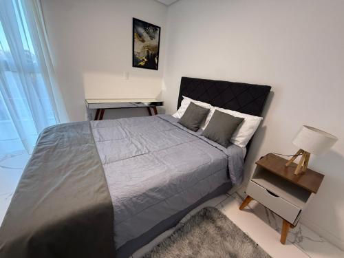 a bedroom with a large bed and a night stand at Apartamento Duplex em Mafra SC in Mafra