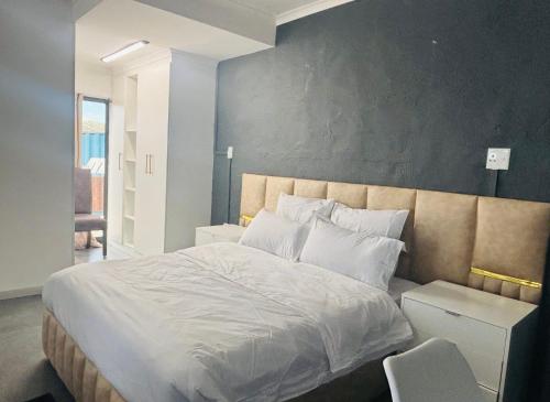 a bedroom with a large bed with white sheets and pillows at Austra Deluxé Villa in Windhoek