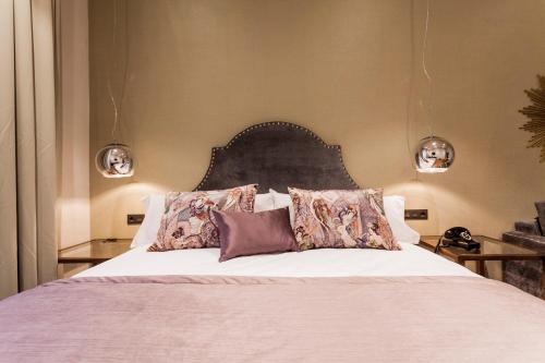 a bedroom with a large bed with pillows at Hotel Palacete de Alamos in Málaga