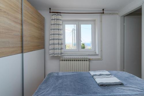 a bedroom with a bed and a window at Apartment Tena in Kraljevica