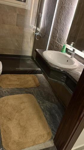 a bathroom with a sink and a toilet with two rugs at chalet - Plumar El Sokhna in Ain Sokhna