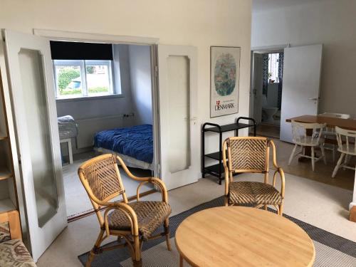 a room with two chairs and a table and a bed at Vejlø Skole - Degnegaarden in Næstved