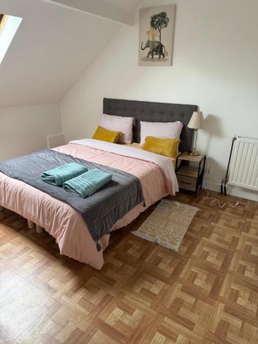 a bedroom with a large bed and a wooden floor at Maison familiale in Gonesse