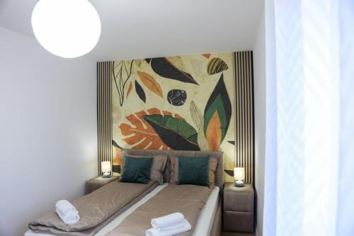 a bedroom with a bed with a painting on the wall at Happy Place Făgăraș in Făgăraş