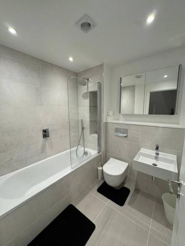 a bathroom with a sink and a tub and a toilet at Tranquil 3BD in Watford in Watford