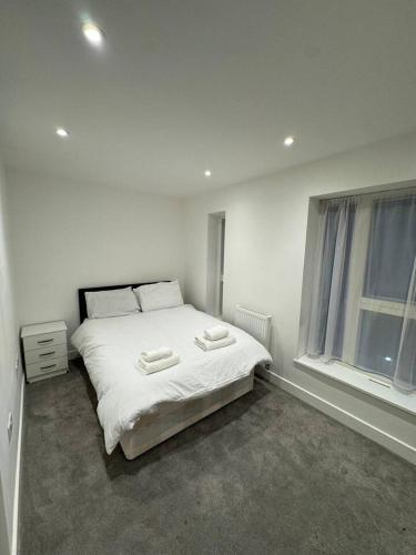 a bedroom with a bed with two towels on it at Tranquil 3BD in Watford in Watford