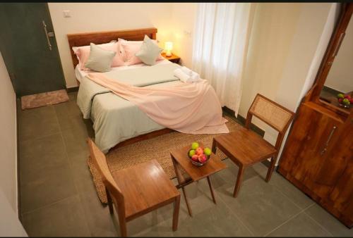 a bedroom with a bed with a table and chairs at Kumarakom Homes in Kumarakom