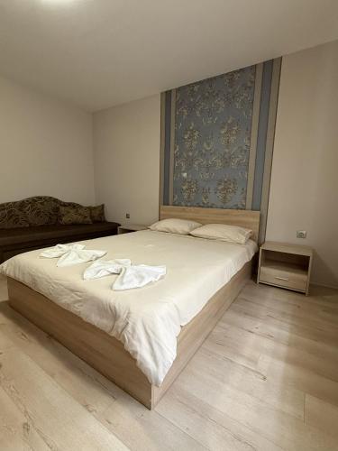 a bedroom with a large bed with towels on it at Guest House STEVi in Devin