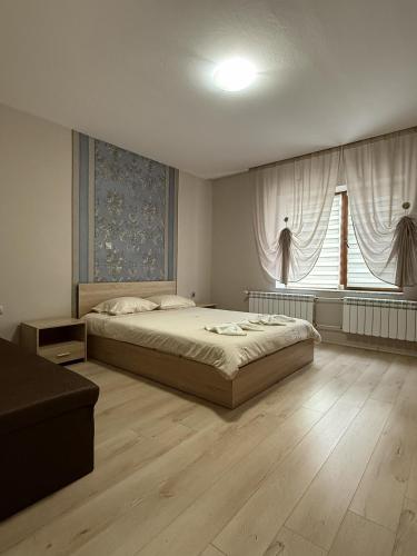 a bedroom with a bed and a large window at Guest House STEVi in Devin
