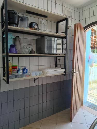 a kitchen with black shelves on a tiled wall at Ubatuba Casa Condomínio Sans Souci 707-14 in Ubatuba