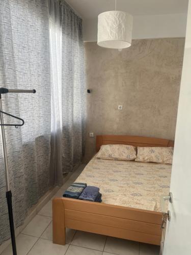 a bedroom with a bed and a window and a lamp at Megalou Alexandrou in Nea Moudania
