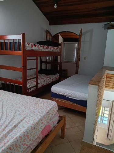 a room with two bunk beds and a window at Ubatuba Casa Condomínio Sans Souci 707-14 in Ubatuba