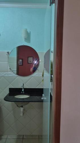 a bathroom with a sink and a mirror at Pousada Elshadai in Uruçuca