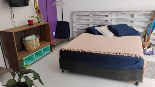 a bedroom with a bed and a wooden headboard at Villa do Condado in Saquarema