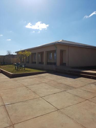 a building with a picnic table in the courtyard at Refiloe Guesthouse in Leribe