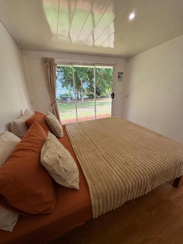 a large bed in a room with a window at Panorama Bungalow in Tahaa