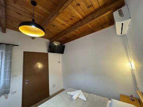 a bedroom with a bed and a wooden ceiling at Bujtina Carku in Theth
