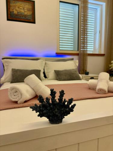 a bedroom with two beds with towels and a plant at Apartment Fortuna in Korčula