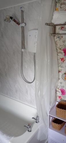 a shower in a bathroom with a white tub at ABC Bladnoch in Newton Stewart