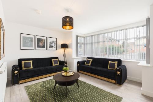 a living room with two black couches and a table at Birmingham Estate - Contractor & Group Accommodation - Secure Parking in Birmingham
