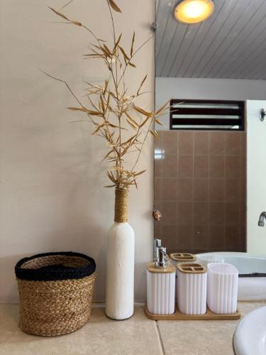 a white vase sitting on a counter in a bathroom at Grand Panorama Villa in Tahaa
