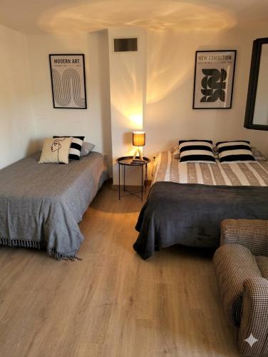 a bedroom with two beds and a table with a lamp at Meimoa Guesthouse in Meimoa