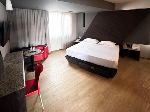 ein Hotelzimmer mit einem Bett, einem Schreibtisch und einem Tisch in der Unterkunft La Moraleja Love hotel in Mexiko-Stadt