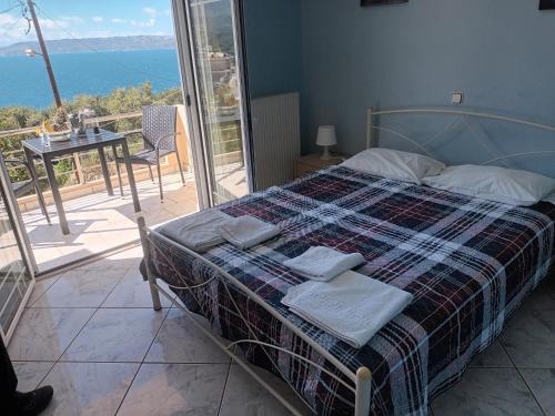 a bedroom with a bed with a view of the ocean at Olympic View Guesthouse in Kalami