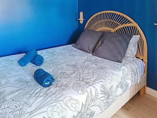 a bed with two blue pillows on top of it at Studio cosy tout équipé, idéal in Chilly-Mazarin