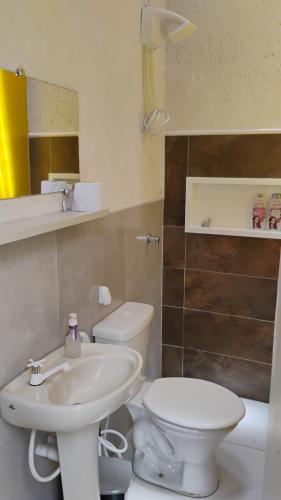 a bathroom with a white toilet and a sink at Villa do Condado in Saquarema