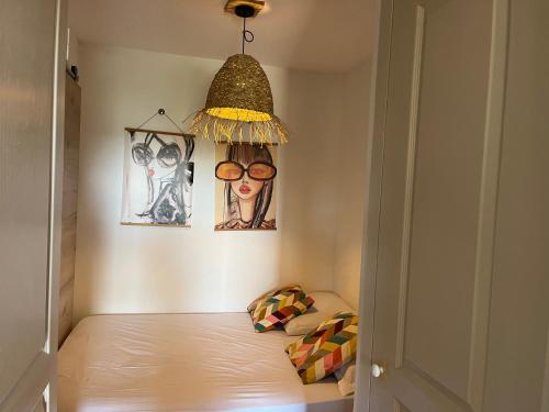 a small room with a bed and a pendant light at Côte d azur Magnifique studio in Les Issambres