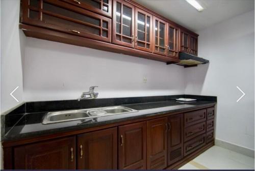 a kitchen with a sink and wooden cabinets at Stargazer Hotel in Danang