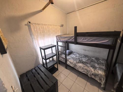 a small room with two bunk beds and a bench at Casa Constructor staff colaboradores in Cabo San Lucas