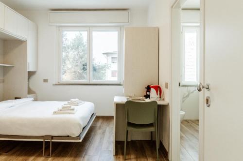 a small bedroom with a bed and a desk at Silvia's Luxury Suites by RentMax in Canegrate