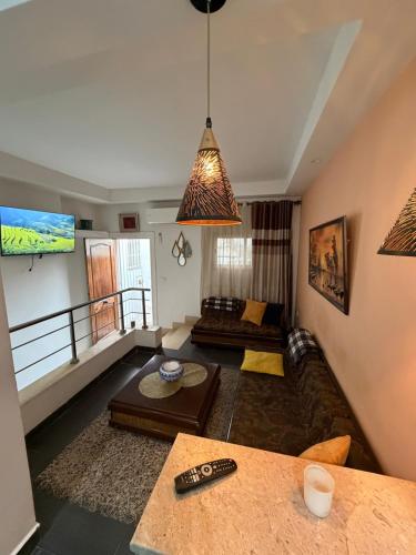 a living room with a couch and a table at Duplex raffiné avec entrée privée in Tunis