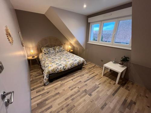 una piccola camera da letto con un letto e due finestre di La Grange Alsacienne a Westhouse