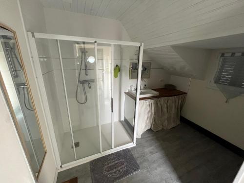 a bathroom with a glass shower in a attic at Maison de Georges et Paulette in Bouesse