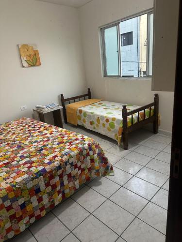 a bedroom with two beds and a window at Apartamento próximo da Praça Mestre Dominguinhos in Garanhuns