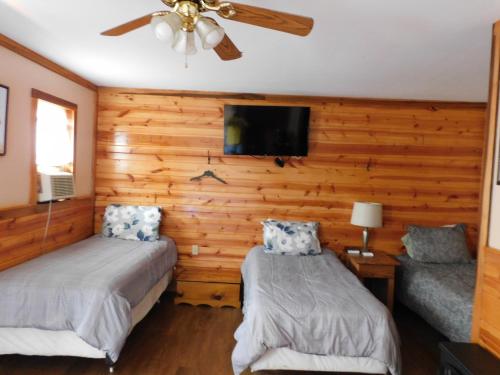 a bedroom with two beds and a ceiling fan at Historic Matewan House Lodging in Matewan