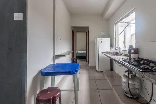 a kitchen with a blue stool and a refrigerator at Apto para 8 pessoas com Garagem e Churrasqueira in Pará de Minas
