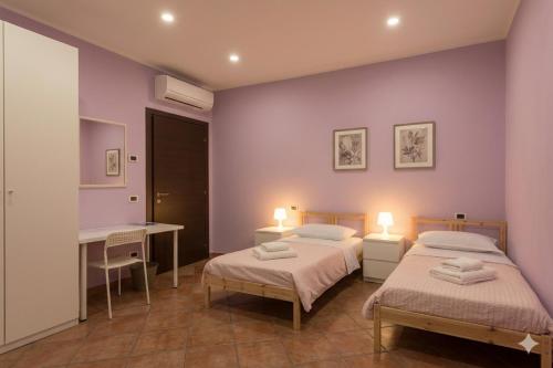 two beds in a room with purple walls at B&B LA PALMA in Ravarino