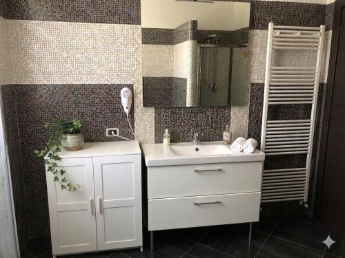 a bathroom with a white sink and a mirror at B&B LA PALMA in Ravarino